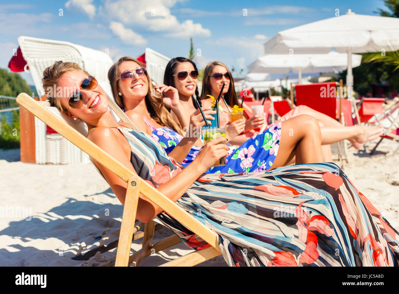 Vier Frauen Am Strand Liege Bräunen In Der Sonne Liegen Stockfotografie 