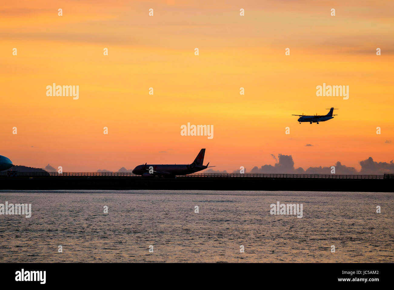 Silhouetten von Flugzeug auf der Landebahn und ein weiteres Landung Stockfoto