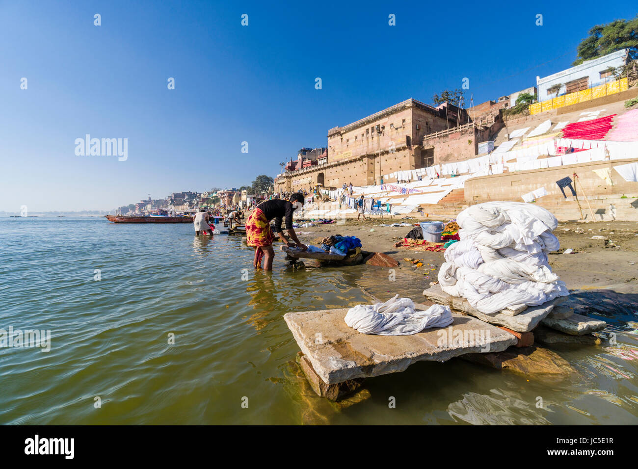Die Wäsche wird gewaschen und von der dhobi Kaste an pandey Ghat zu trocknen am heiligen Fluss Ganges in der Vorstadt godowlia Stockfoto