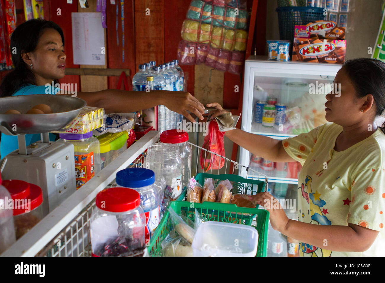 Ein Frauen dient ein Kunde in ihrem Shop, Indonesien, Asien. Stockfoto