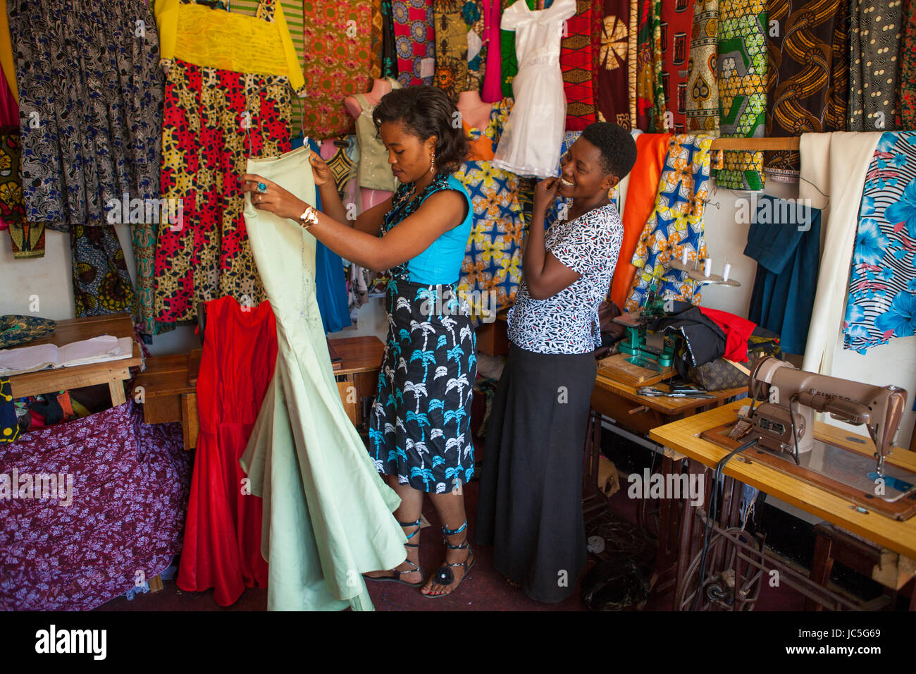 Ein kleines Unternehmen Frau Schneider mit einem Kunden einige Gewebe in Ihrem Shop, Tansania, Afrika. Stockfoto
