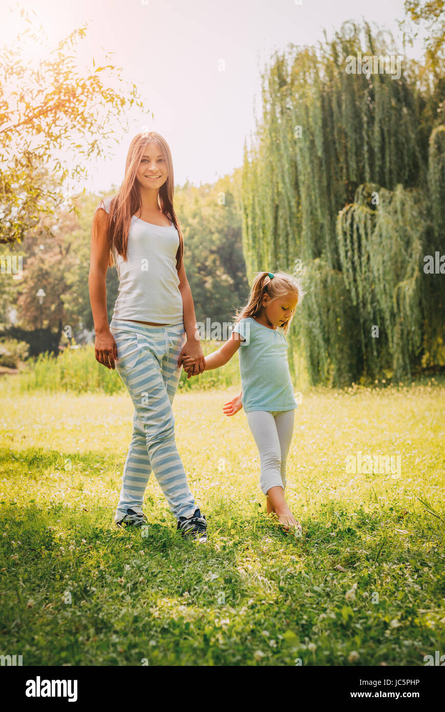 Schöne Mutter und Tochter ein Spaziergang durch einen Park im Frühling. Stockfoto