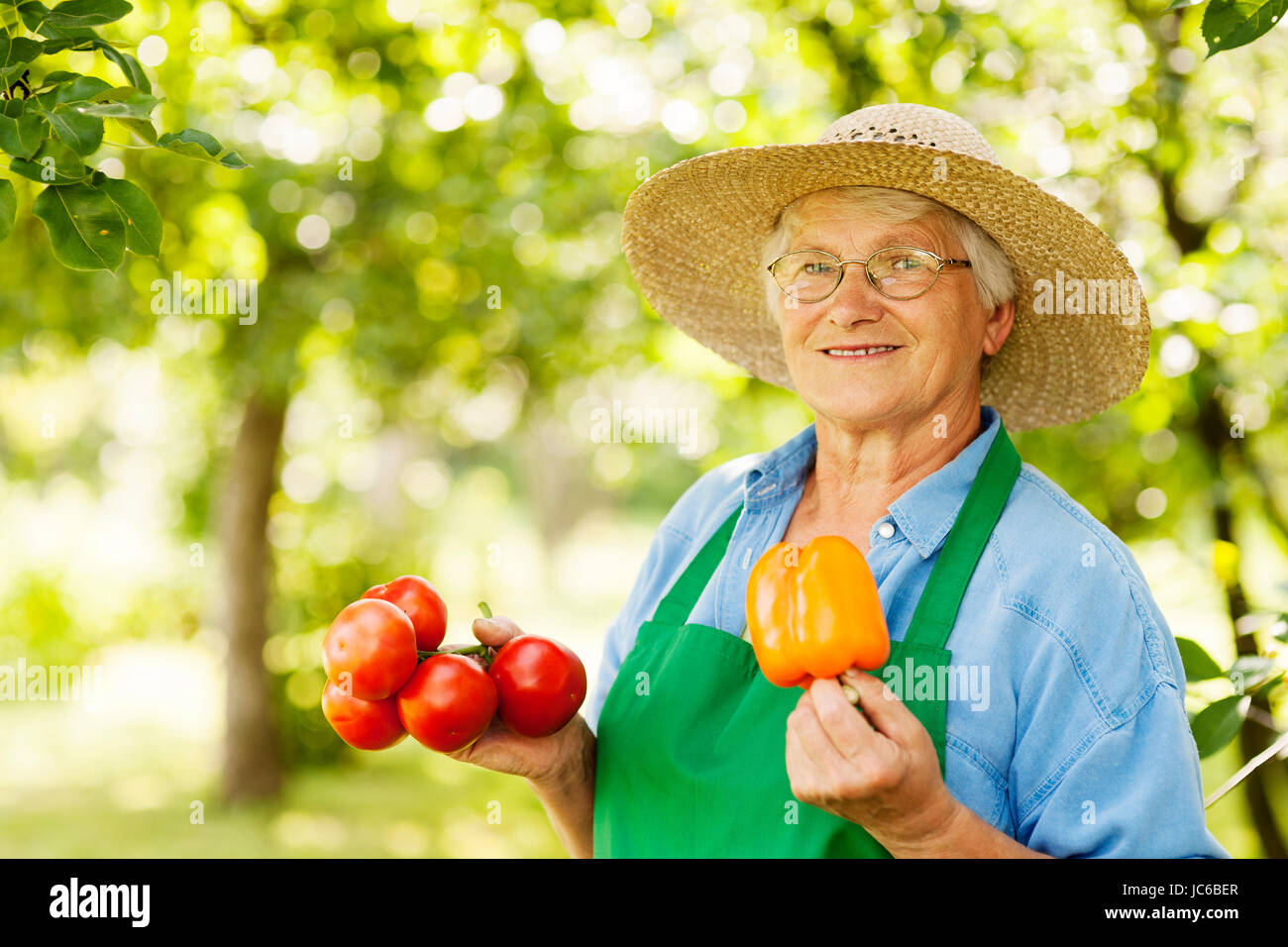Ältere Frau mit Tomaten und gelbe Paprika Stockfoto