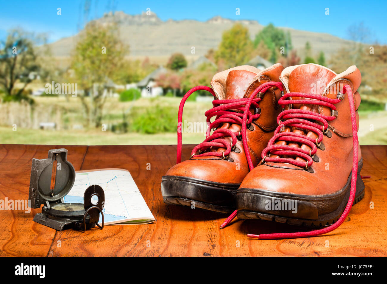 Wanderschuhe, Karte und Kompass mit Berg im Hintergrund Stockfoto