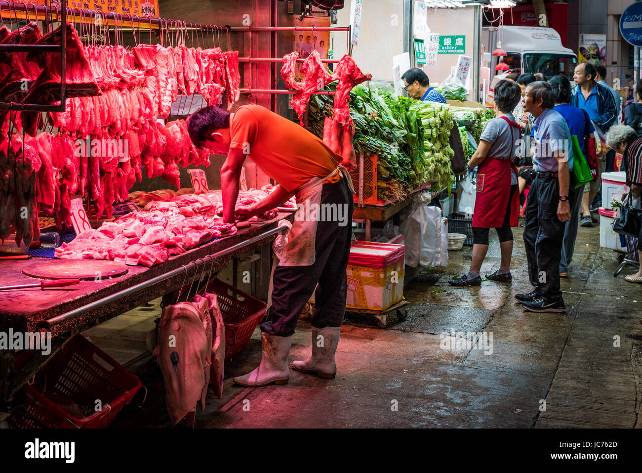 Rote Lichter markieren Sie frische Fleischstücke auf der Metzgerei Stall. Schausteller bei der Arbeit mit Kunden zu interagieren. Stockfoto