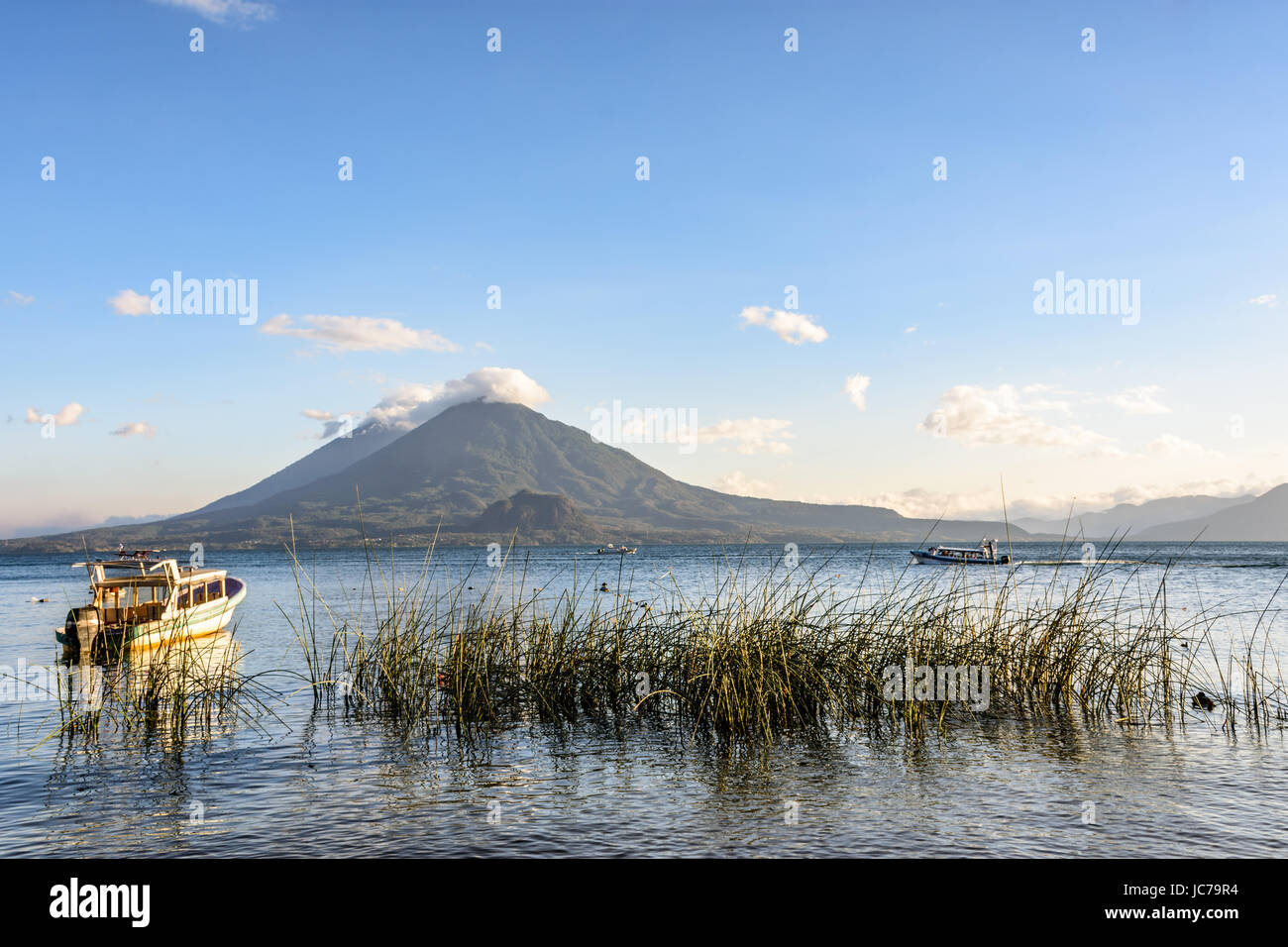 Abendlicht auf Boote & zwei Vulkane, Atitlán und toliman, am Atitlan See, Guatemala. Stockfoto
