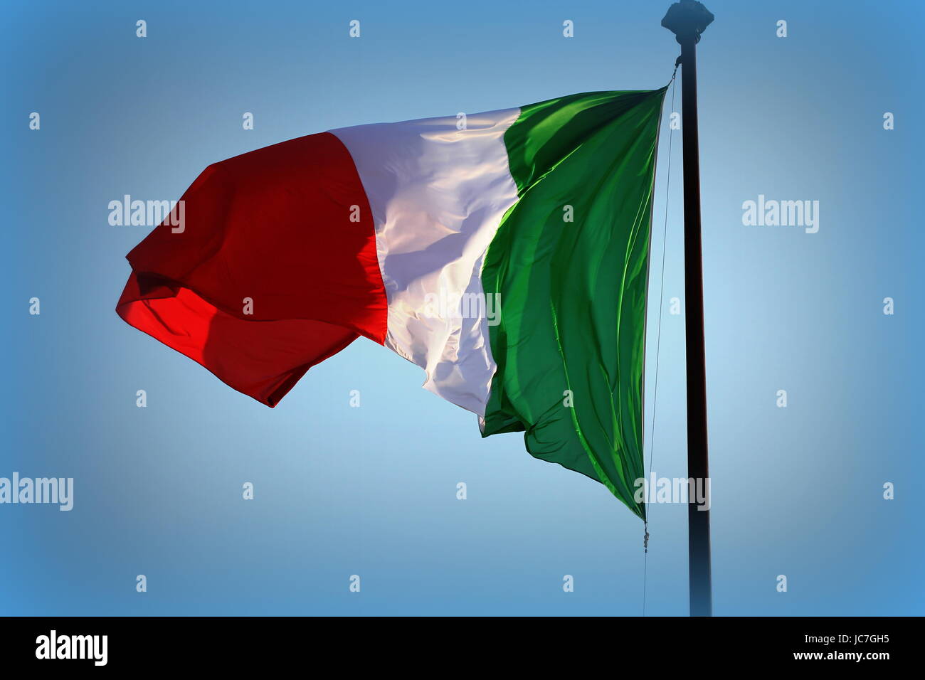 Italienische Fahne flattert im Wind, mit blauem Himmel Stockfoto