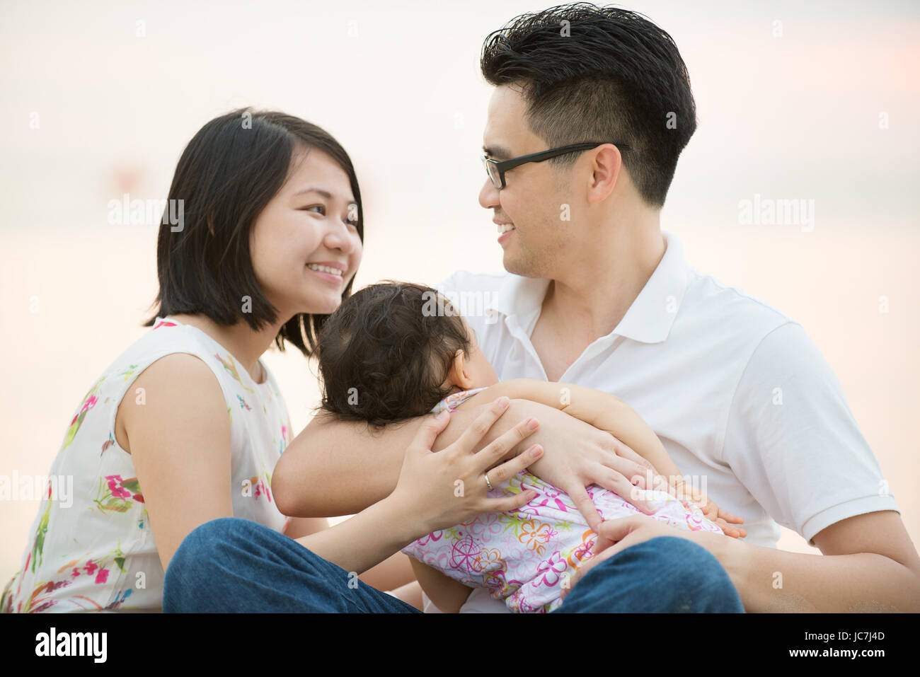 Asiatischen Familie am Strand im Freien, Urlaub im Sommer, natürliche Sonnenuntergang Sonne sitzen. Stockfoto