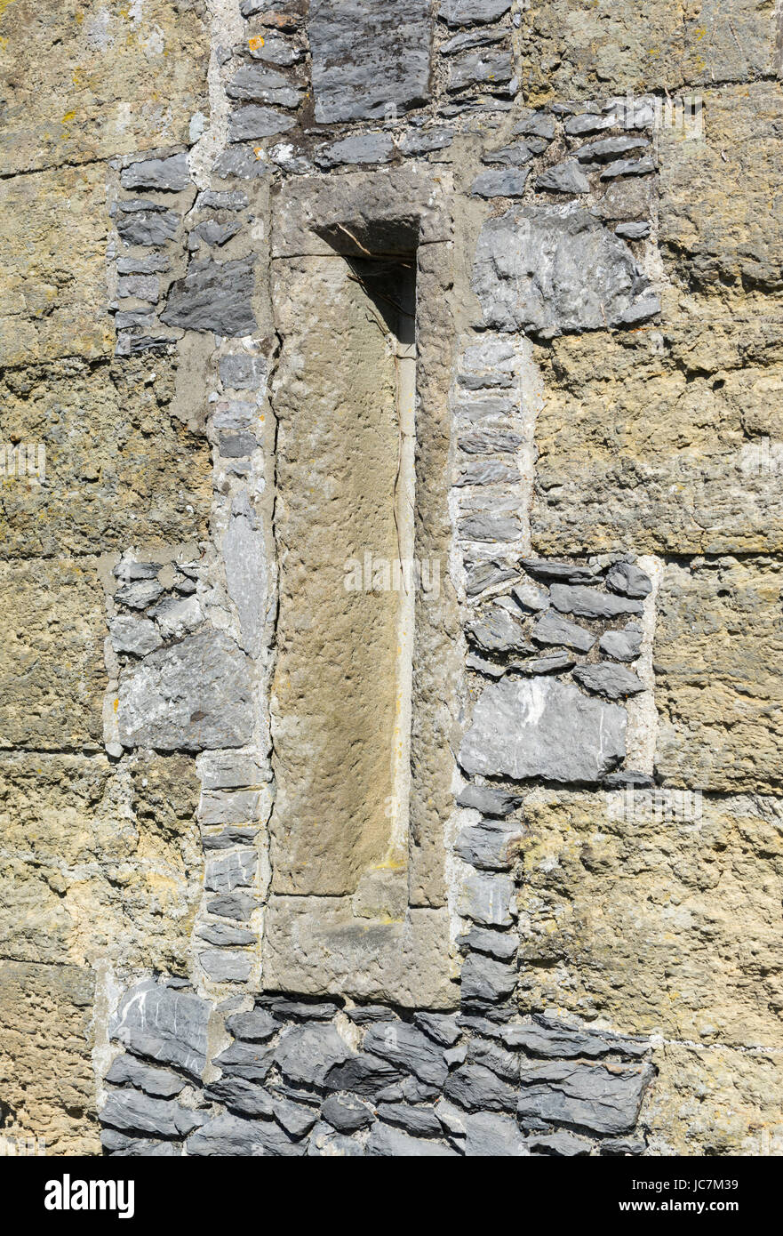 Arrowslit auf einer steinernen Burgmauer im Vereinigten Königreich. Pfeil-Schlitz. Stockfoto