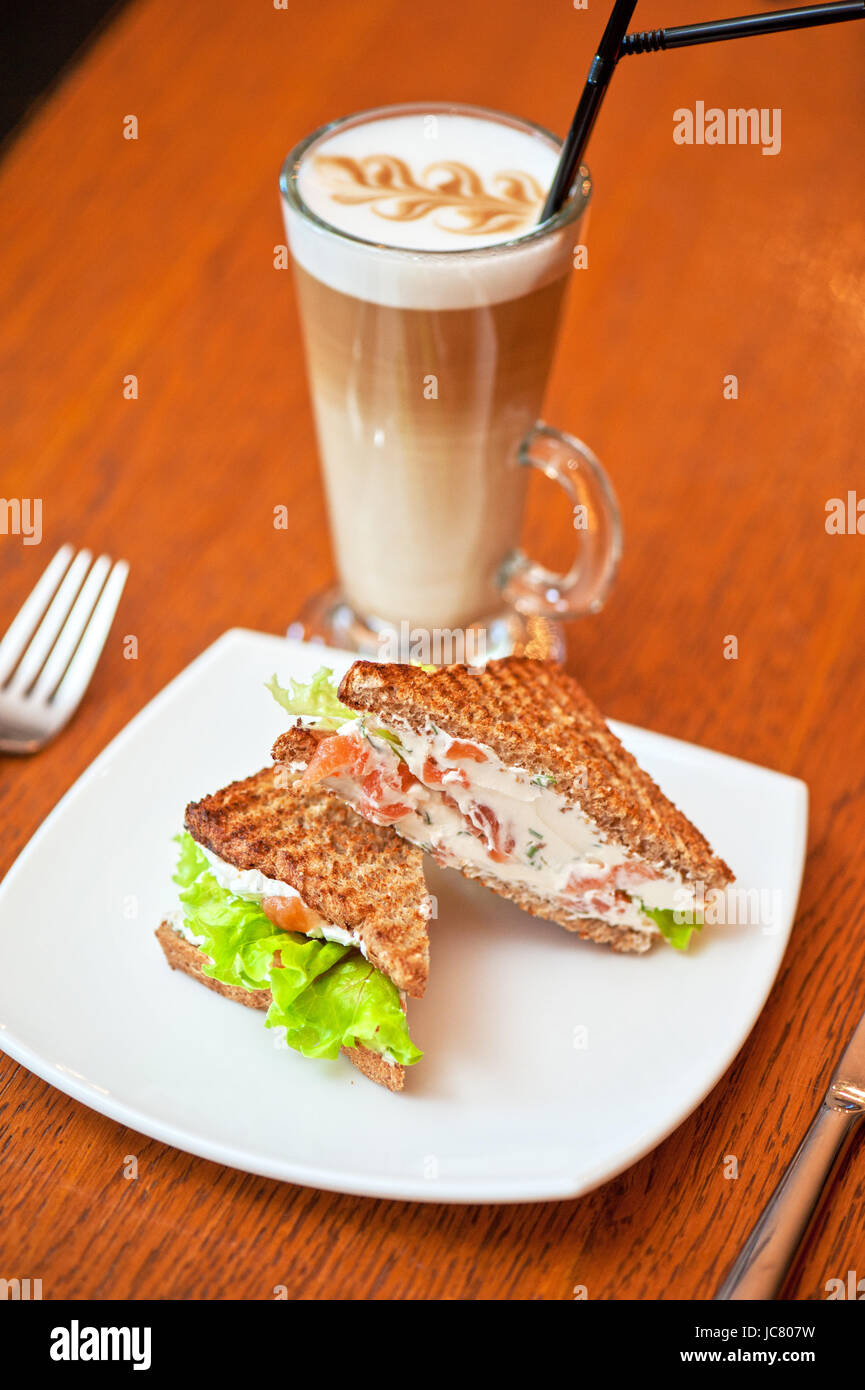 Sandwich mit Käse und Lachs und Gemüse mit latte Stockfoto