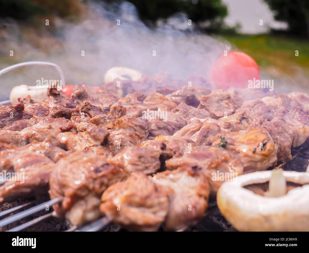 Schaschlik, über einem schwarzen Runde geformten Holzkohlegrill im freien zubereitet Stockfoto