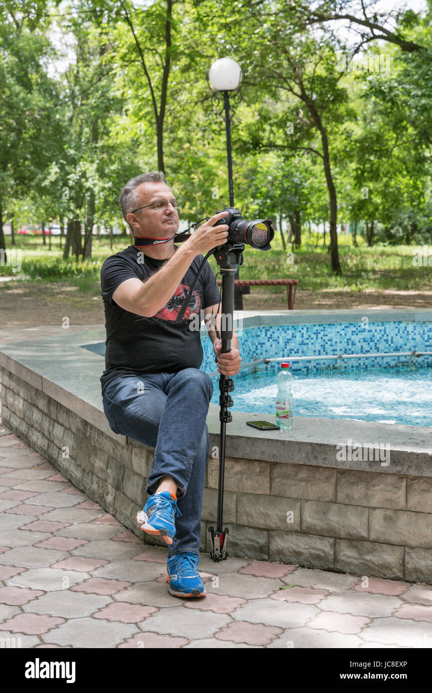 WOSNESENSK, UKRAINE - 2. Juni 2017: Berühmte ukrainische Videofilmer Andriy Melko mit Canon 5 D Mark III Kamera Einbeinstativ in Stadt Park Dur schießt und Stockfoto