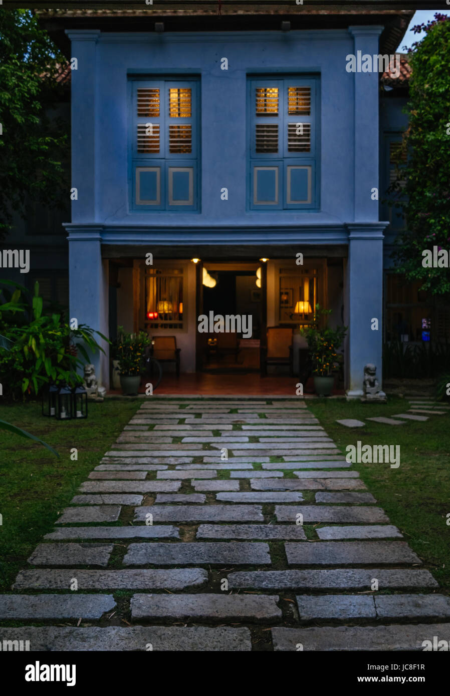 Stein Weg in Richtung ein Haus im Kolonialstil mit kleinen Lichtern beleuchtet während der Dämmerung in George Town, Penang, Malaysia Stockfoto