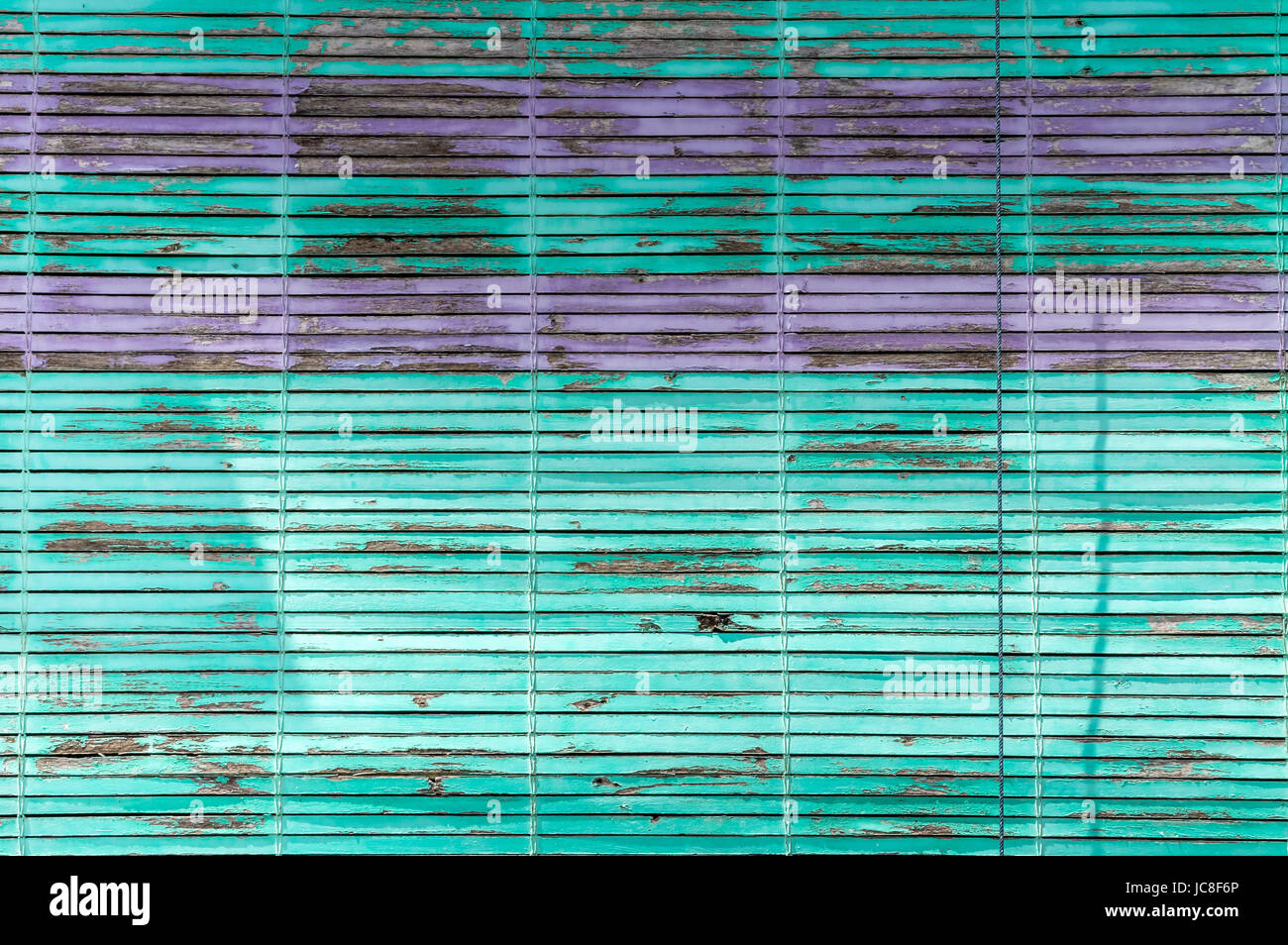Grün und lila horizontale Jalousien Lamellen mit abblätternde Farbe Stockfoto