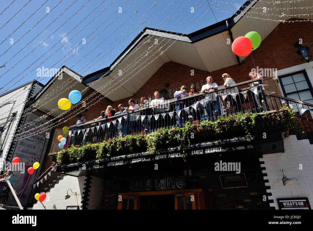 Nachtschwärmer genießen Sie einen Drink auf dem Balkon des The Grosvenor Cafe in Ashton Lane, Glasgow, Schottland während des West-End-Festivals. Stockfoto