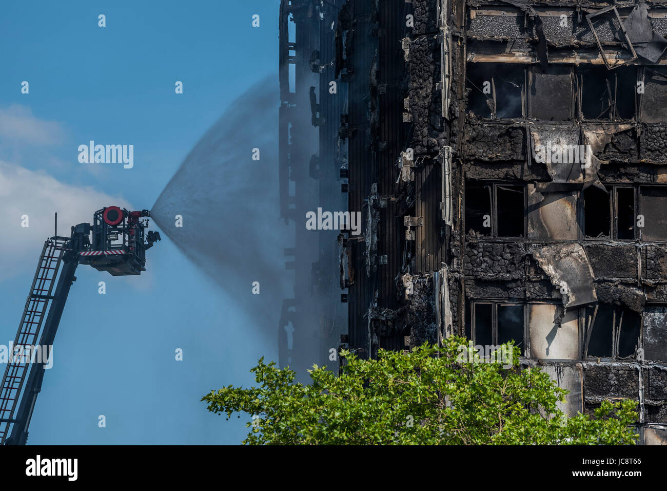 London, UK. 14. Juni 2017. Die Feuer-Service-Wasserstrahl Schläuche das Gebäude aber nur etwa auf halbem Weg oben erreicht. Grenfell Tower - die verkohlten Überreste des Hochhauses, die letzte Nacht in North Kensington in der Nähe von u-Bahnstation Latimer Road in geraten Brand. London 14. Juni 2017. Bildnachweis: Guy Bell/Alamy Live-Nachrichten Stockfoto