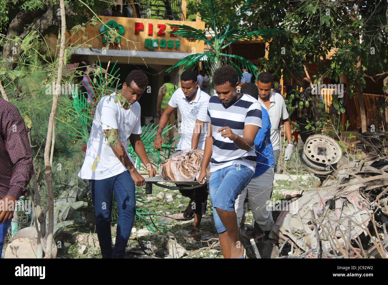 Mogadischu, Somalia. 15. Juni 2017. Menschen tragen den Körper des Opfers bei der Explosion in Mogadischu, Hauptstadt von Somalia, 15. Juni 2017. Bewaffnete am Mittwoch Abend, zwei Restaurants in Somalias Hauptstadt Mogadischu angegriffen mindestens 18 Menschen getötet, sagte ein Regierungssprecher. Bildnachweis: Faisal Isse/Xinhua/Alamy Live-Nachrichten Stockfoto