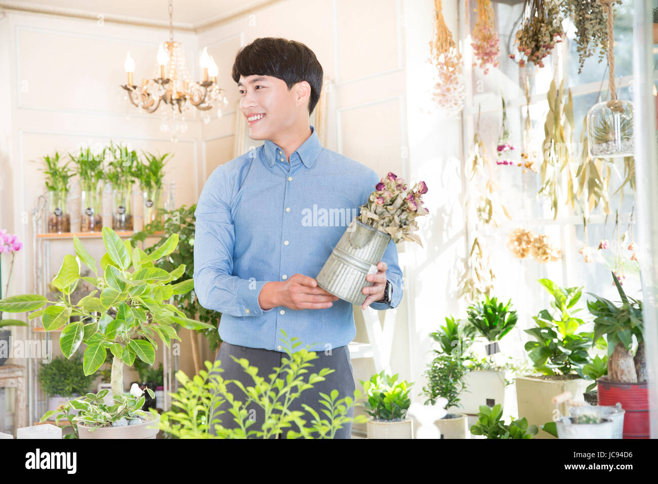 Junger lächelnder Mann Blumen kaufen Stockfoto