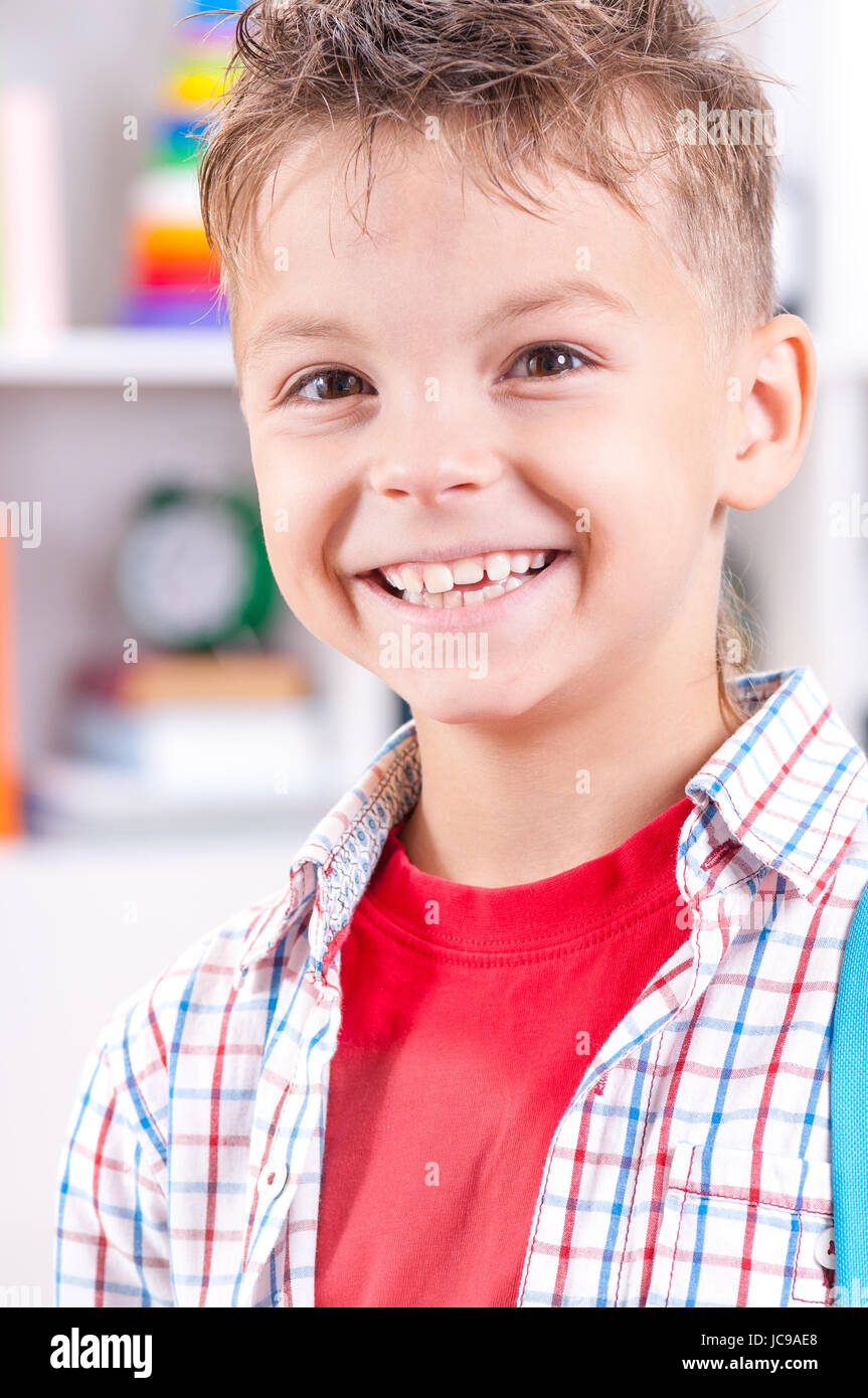 Porträt von glücklich lächelnde junge Blick in die Kamera hautnah. Kind im Klassenzimmer oder zu Hause. Stockfoto