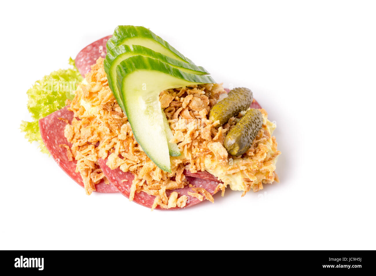 Dänische Spezialitäten und nationale Gerichte, qualitativ hochwertige Open Sandwich, Salami mit knusprig gebraten, Zwiebel, Remoulade und Gurke isoliert auf weißem Zeitmessung Stockfoto