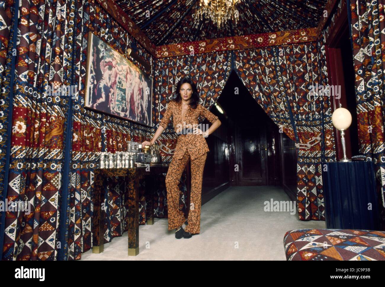 Die belgisch-amerikanische Geschäftsfrau Diane von Fürstenberg in ihrer Wohnung der Park Avenue in New York. Sie posiert in der marokkanischen Stil Bar-Ecke, und sie trägt einen Safari braunen Anzug Shorty Blick (DVF-Label).  1975 Foto Michael Holtz Stockfoto