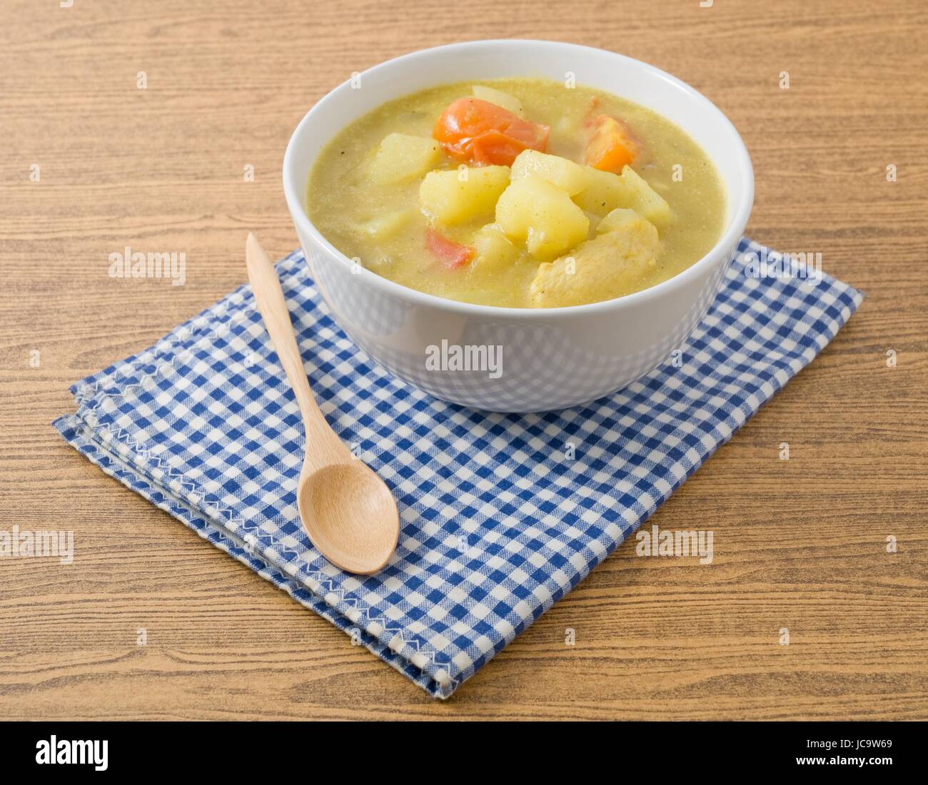 Küche und Essen, eine Schüssel mit Curry-Eintopf mit geschnittenen Kartoffeln, Tomaten und Hühnchen. Stockfoto