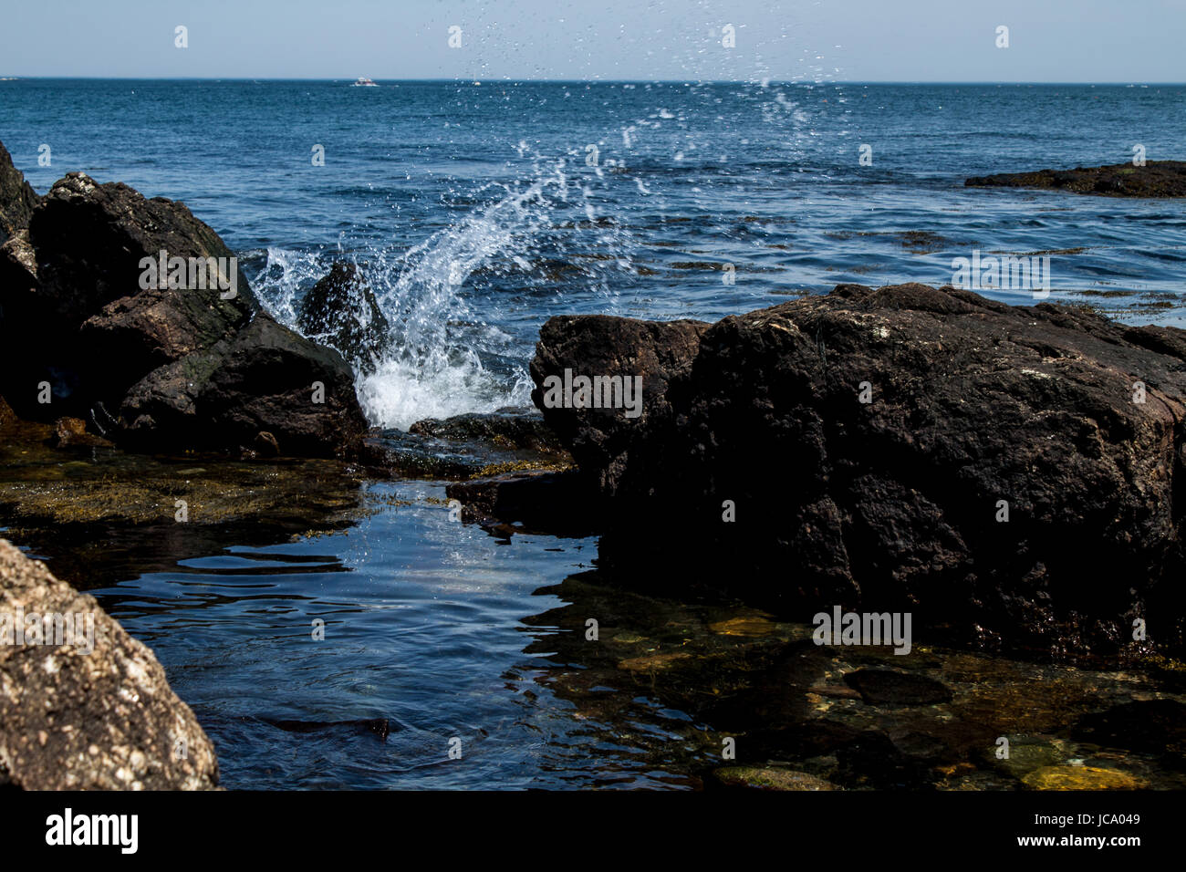 Eine erstaunliche Foto einer Welle senden Gischt Lichtbögen über einen Felsen. Stockfoto