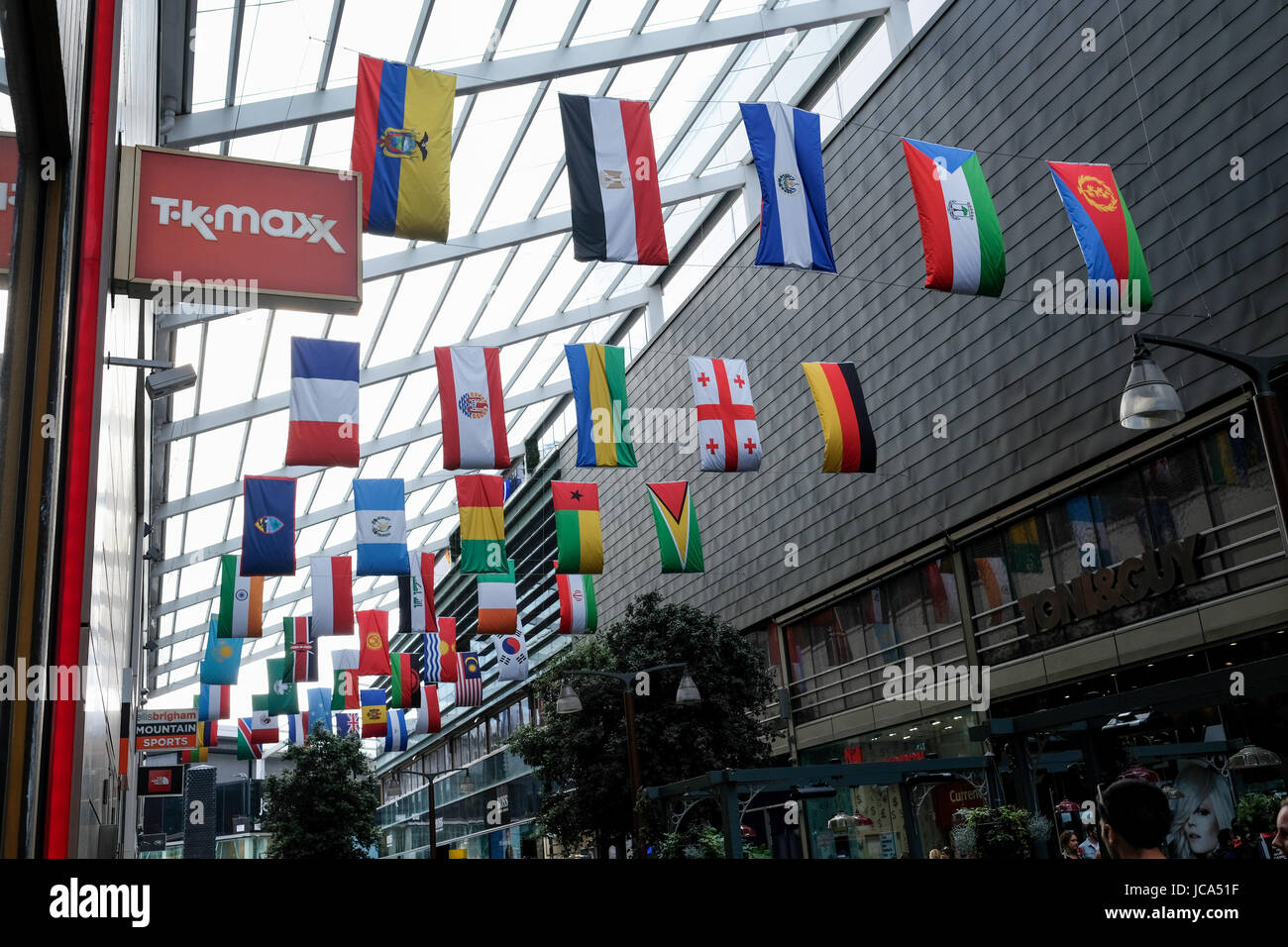 Fahnen aus verschiedenen Ländern der Welt werden im Einkaufszentrum Westfield in Stratford, London, UK angezeigt. TK Maxx speichern Zeichen. Stockfoto