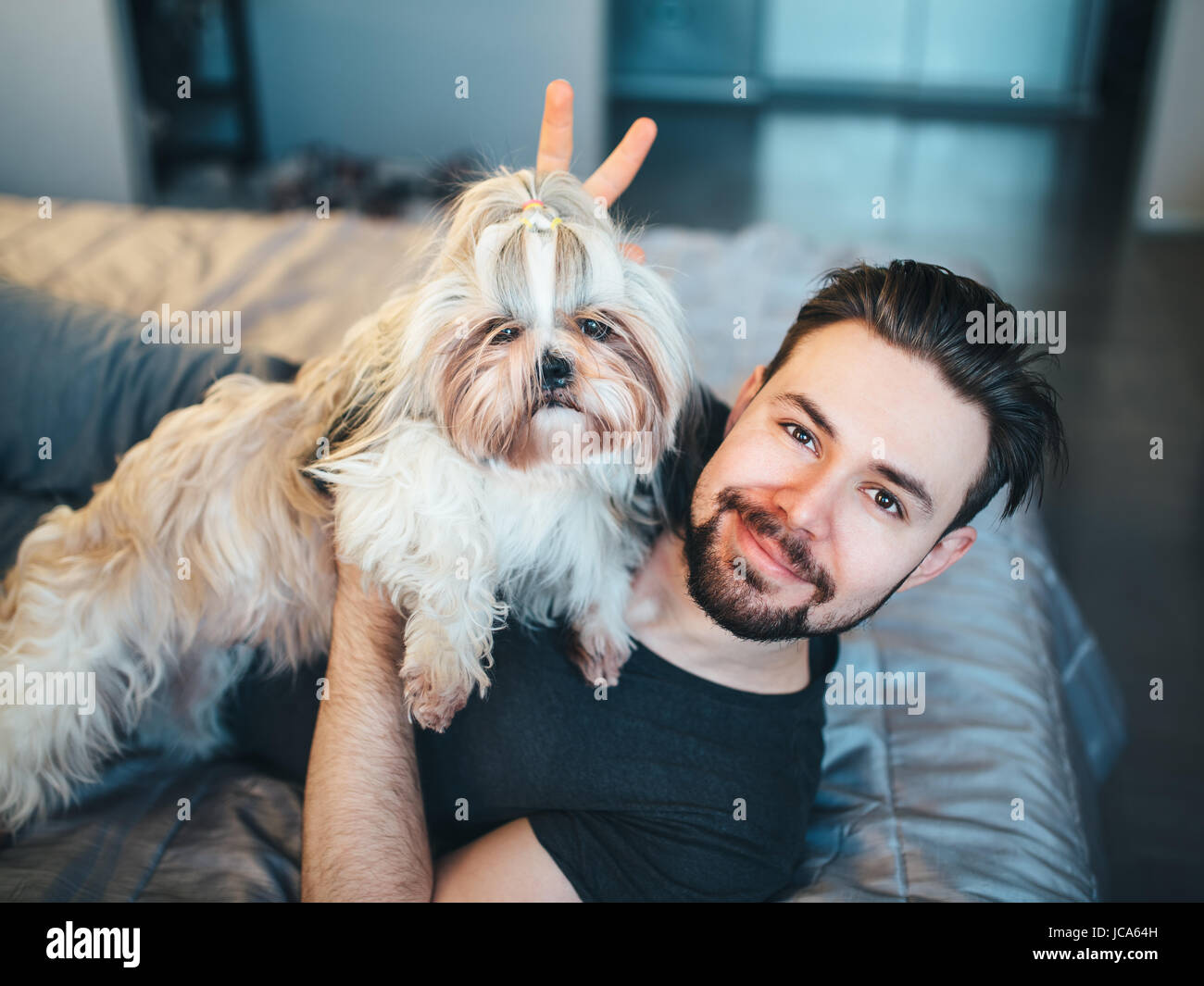 Junger Mann mit Shih Tzu Hund Portrait. Liebe und Spaß-Konzept. Stockfoto
