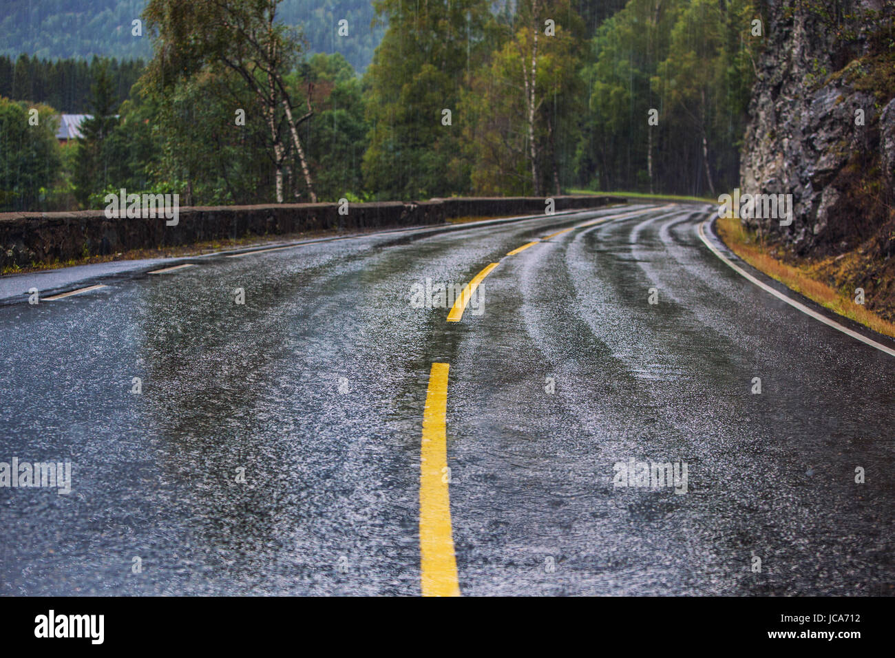 Nasser Fahrbahn mit dreht sich bei Regen in Norwegen. Auto fahren Sicherheitskonzept. Stockfoto