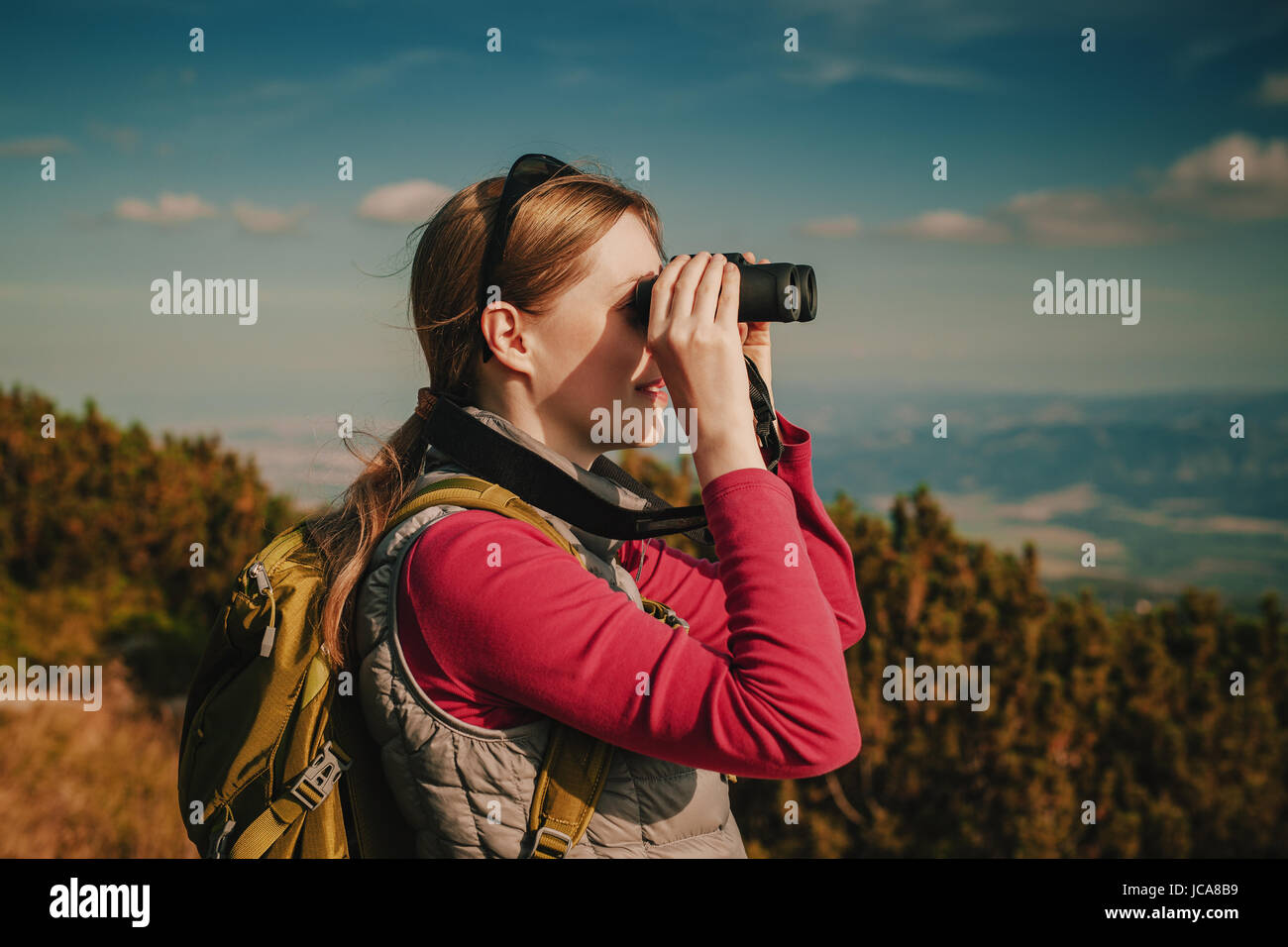 Junge Frau Tourist mit dem Fernglas suchen in den Bergen Stockfoto