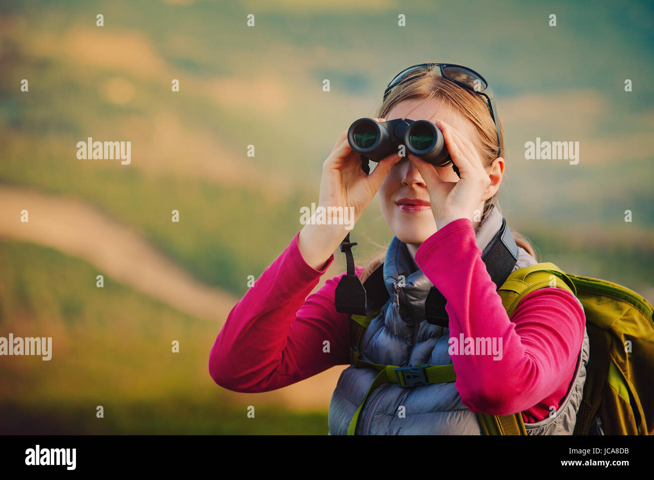 Junge Frau Tourist mit dem Fernglas suchen in den Bergen Stockfoto