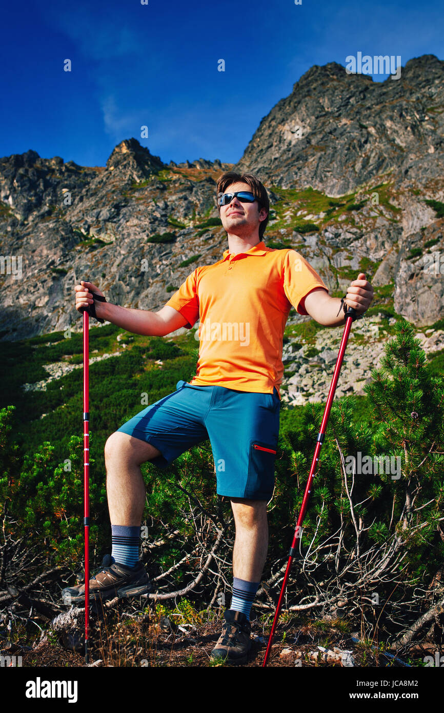 Junger Mann touristischen Stand an hohen Bergen und sah zur Seite Stockfoto