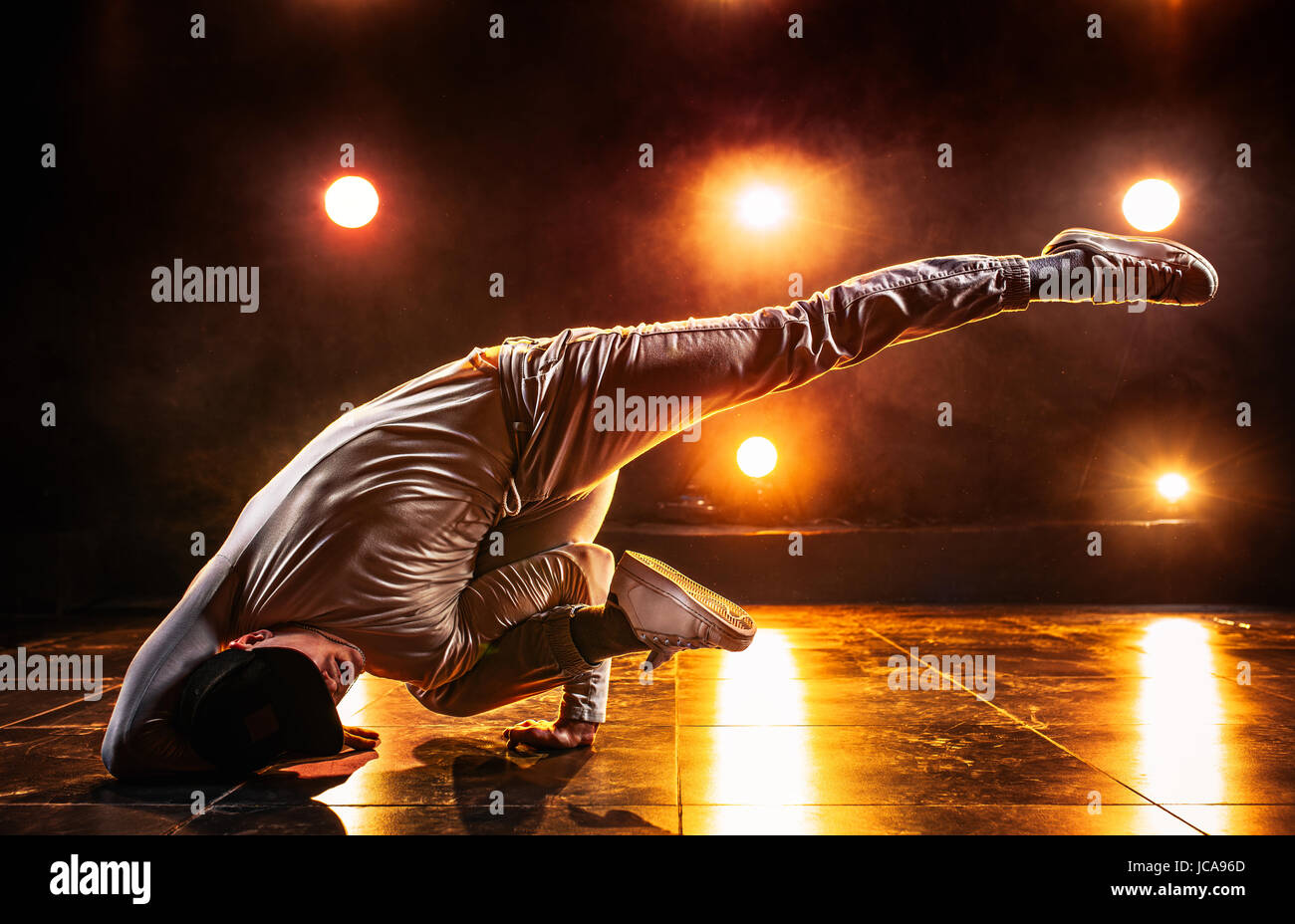Junger Mann Breakdance im Club mit roten Lichtern. Lebendige kontrastreichen Farben. Stockfoto
