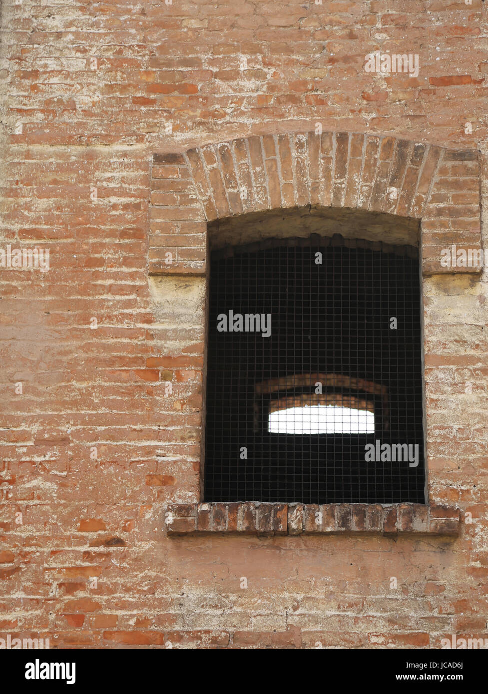 Fenster von einem alten Backsteinbau mit eisernen Gittern Stockfoto
