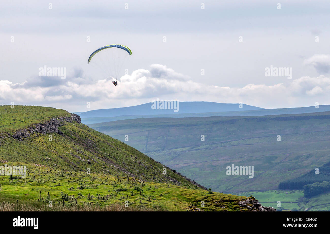 Mitglied der Dales Drachenfliegen und Paragliding Club fliegt einen Gleitschirm in der Nähe von Hirschen fiel in den Yorkshire Dales National Park. Stockfoto