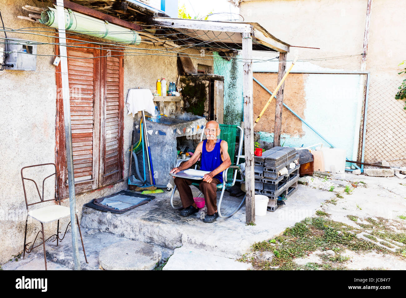 Kubanische Greis mit Tablett mit Reis auf Schoß, Reis sortieren, zählen Getreide Reis, kubanischen Garten, kubanischen Mann, Greis, Rentner, Senioren, armer Mann, Armut Stockfoto