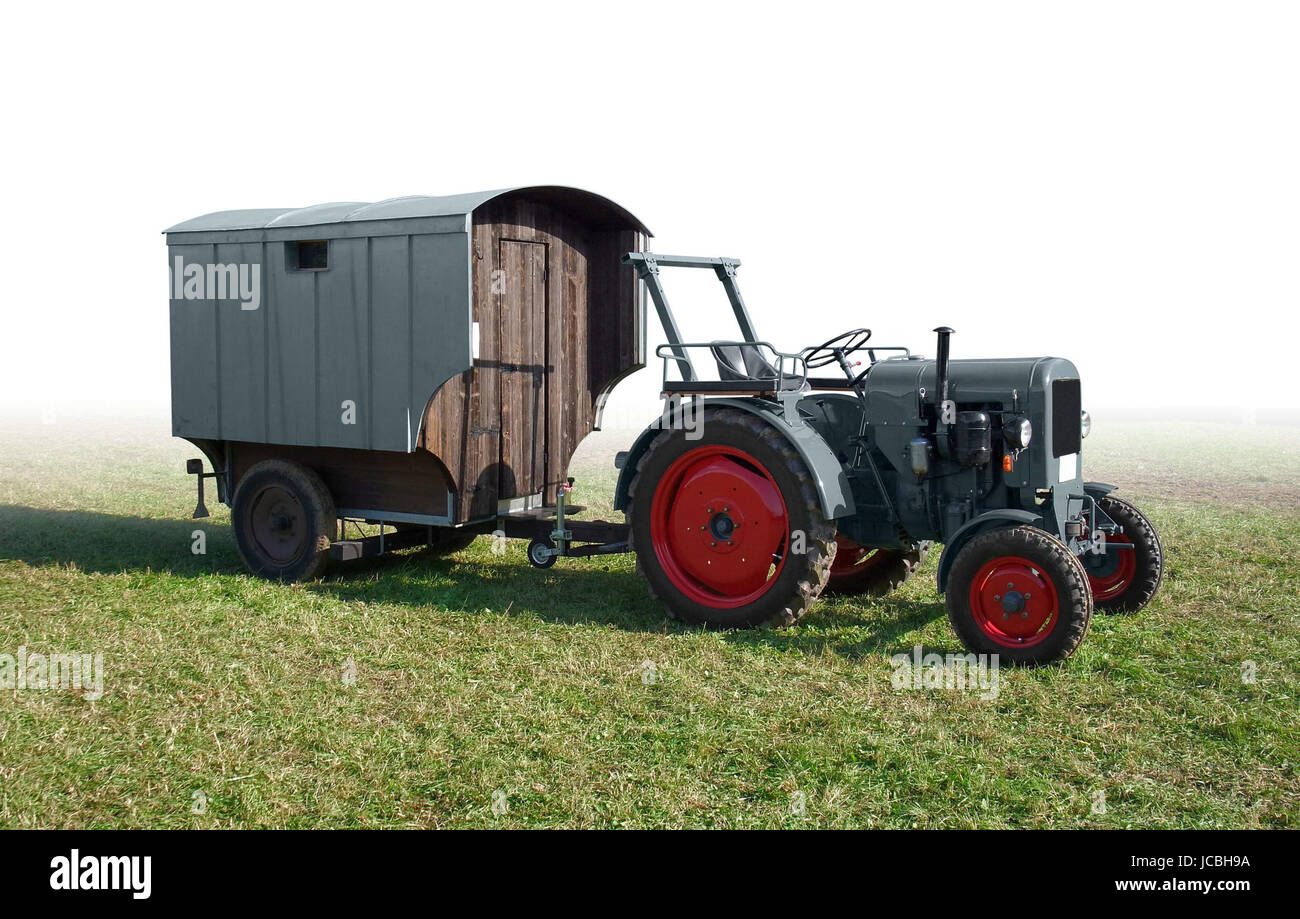 historischen Zugmaschine mit heruntergekommenen Anhänger auf einer Wiese, gradient isoliert Stockfoto