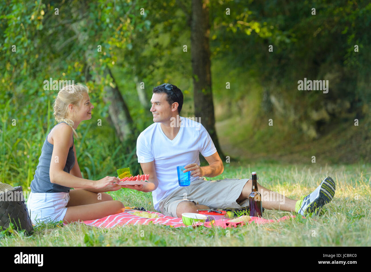 nettes Paar mit Picknick auf einer Decke liegend Stockfoto