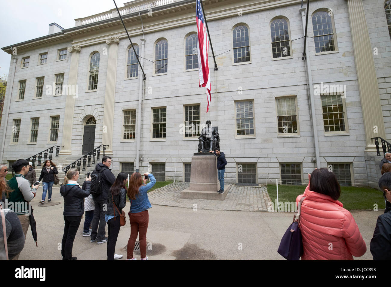 Touristen posieren für Fotos bei John Harvard Denkmal auf dem Campus der Harvard Universität Boston USA Stockfoto