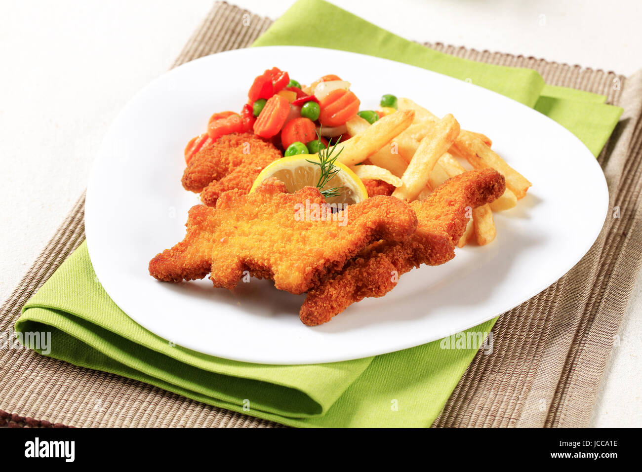 Gebratene panierte Fisch serviert mit Pommes Frites und gemischte Gemüse Stockfoto