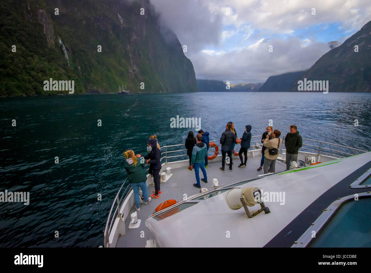 Nicht identifizierte Krone des Menschen erhalten die wunderschöne Landschaft des hohen Berg Gletscher am Milford Sound mit einem schönen See, im Süden der Insel im neuen Z Stockfoto