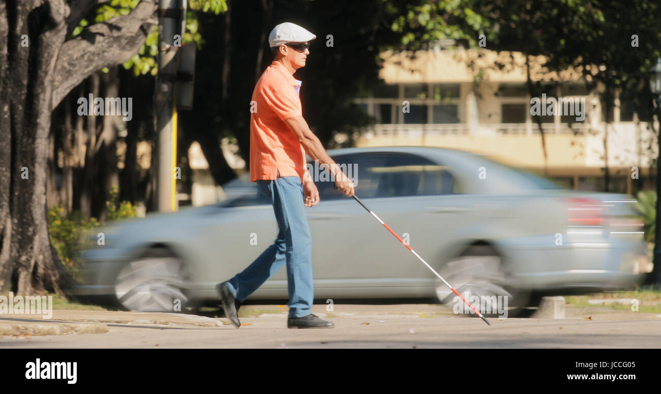 Hispanische blinder, Latino-Menschen mit Behinderung, Behinderte Person und Alltag. Blinden und sehbehinderten Mann mit Spazierstock, die Straße überqueren Stockfoto