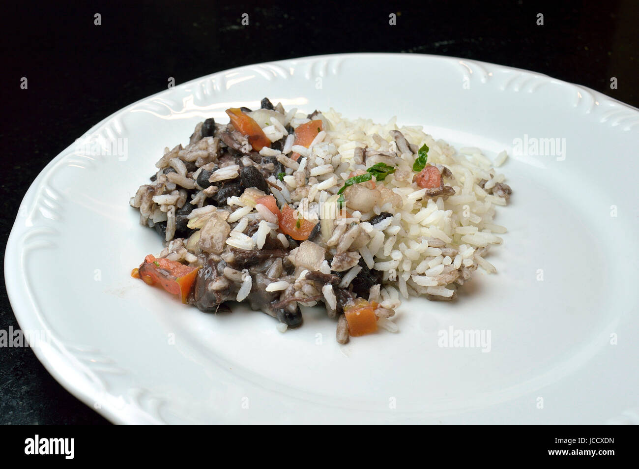 Portion Reis, Bohnen und Tomaten auf einem weißen Teller Stockfoto