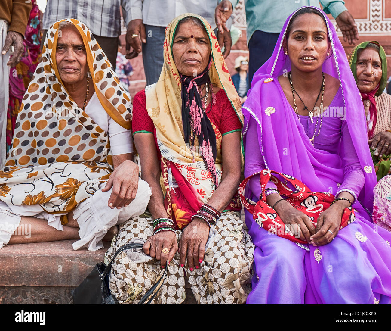 AGRA, Indien - 19. November 2016: Drei Frauen in bunten Saris und Hijabs sitzen am Eingang in das große Tor des Taj Mahal in Agra, Indien Stockfoto