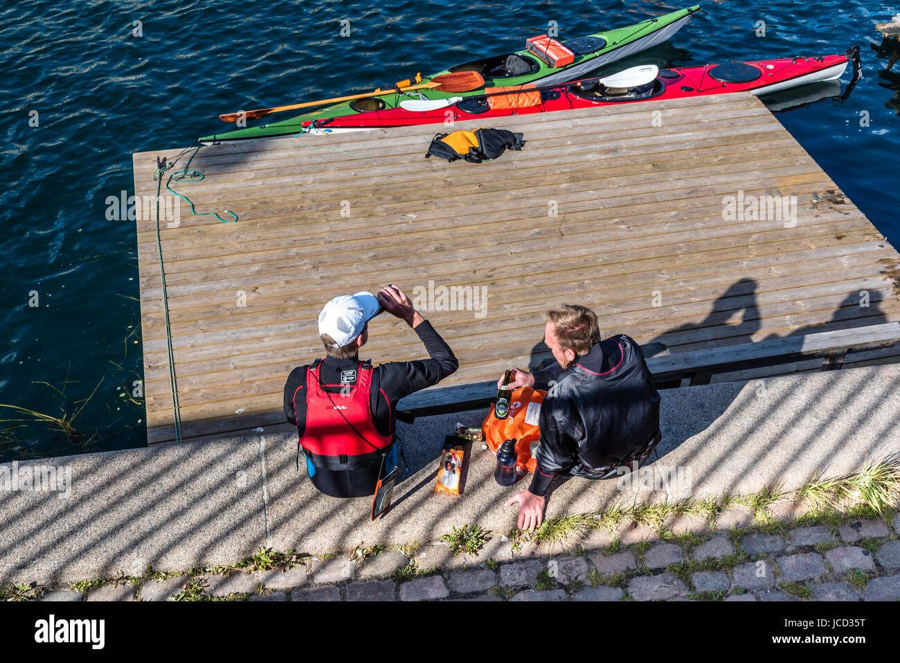 Kopenhagen, Dänemark - 11 August 2016: kanuten Ausruhen nach Übung und trinken Bier sitzen auf Waterfront von Kopenhagen in einem sonnigen Sommertag. Stockfoto