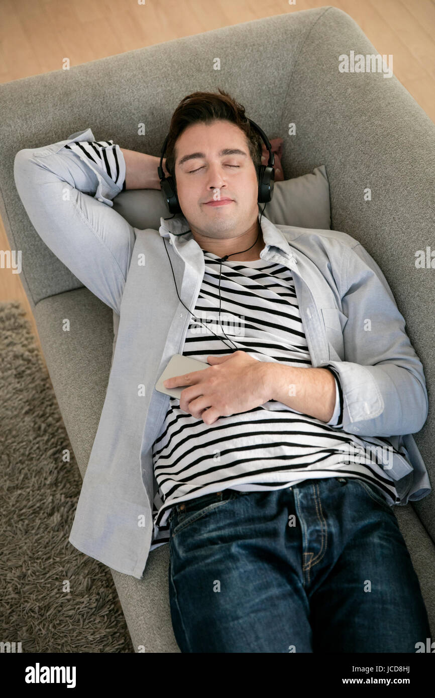 Entspannen Sie sich auf Sofa Musikhören westliche Mensch Stockfoto