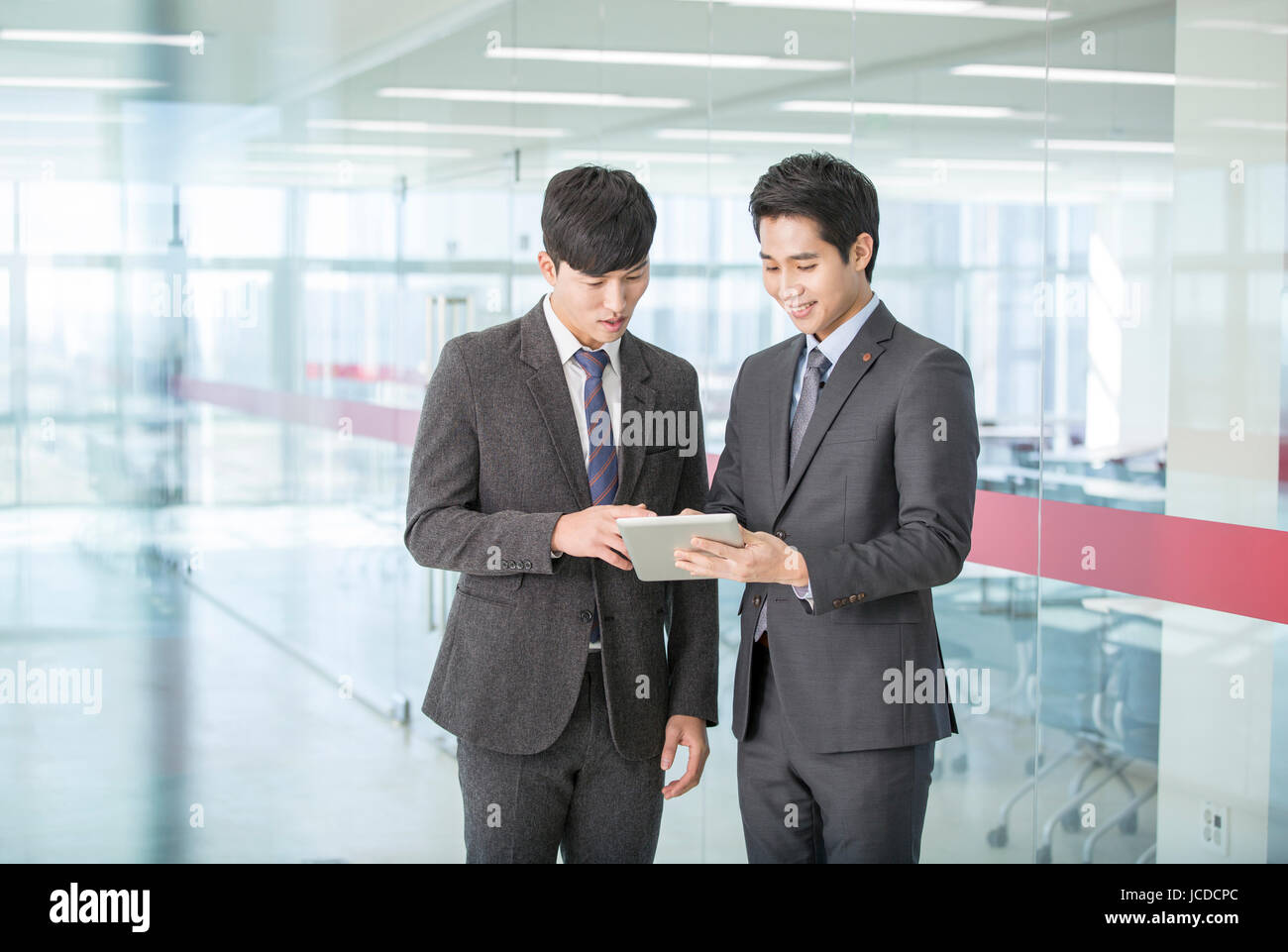 Zwei Lächelnde Geschäftsleute eine Tablette teilen Stockfoto