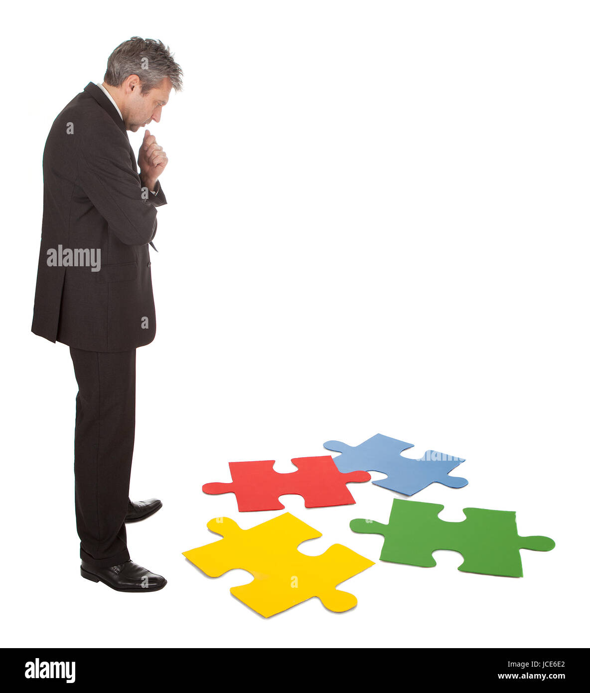 Leitenden Geschäftsmann Montage eine Puzzle. Isoliert in weiss Stockfoto