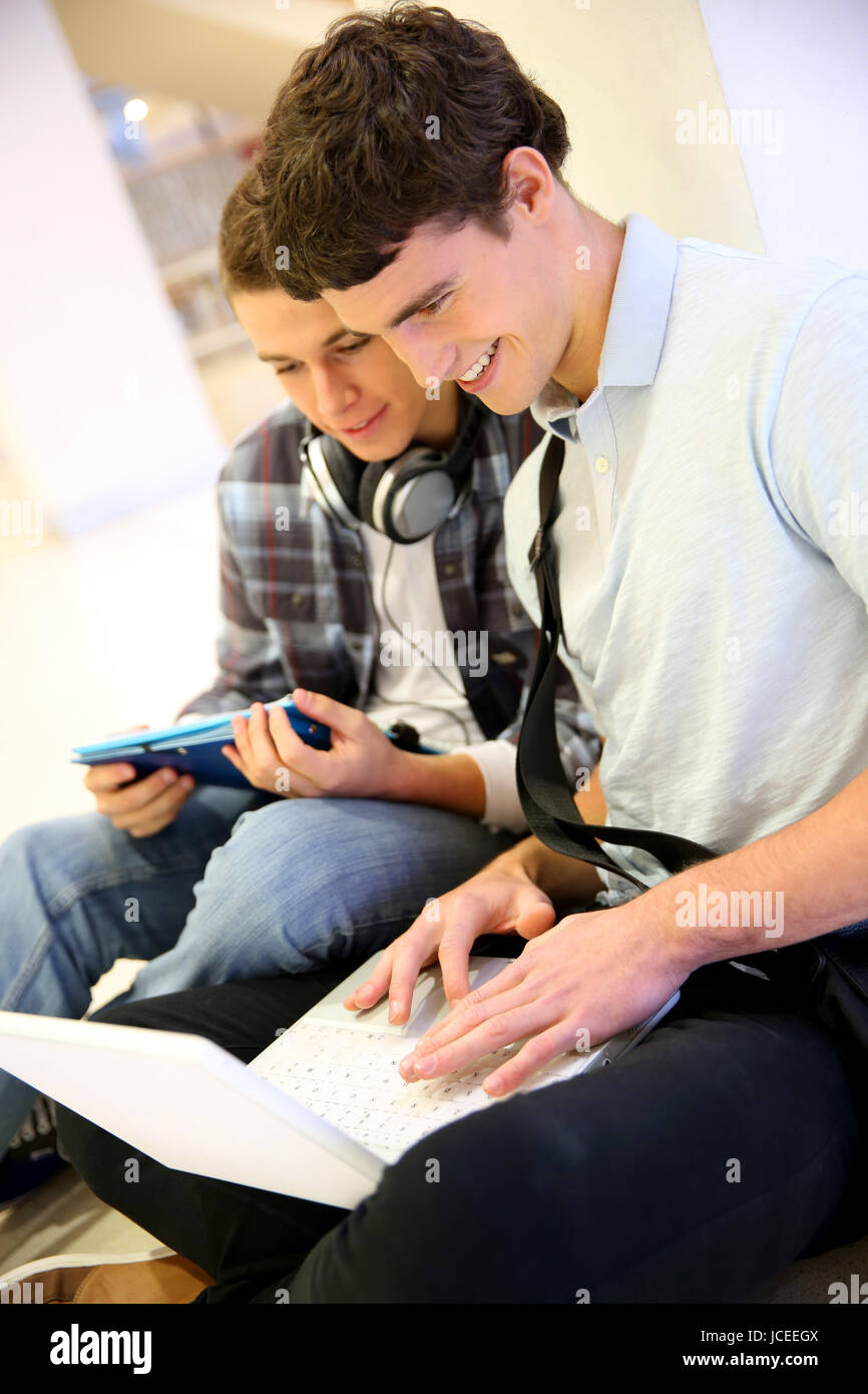 Jungen mit Laptop-Computer im Schulgebäude Stockfoto